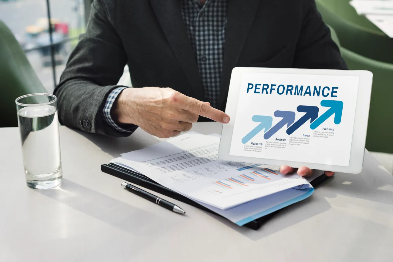 Geschäftsmann analysiert Performance-Daten auf einem Tablet mit Fokus auf die Digital Branding Strategie.